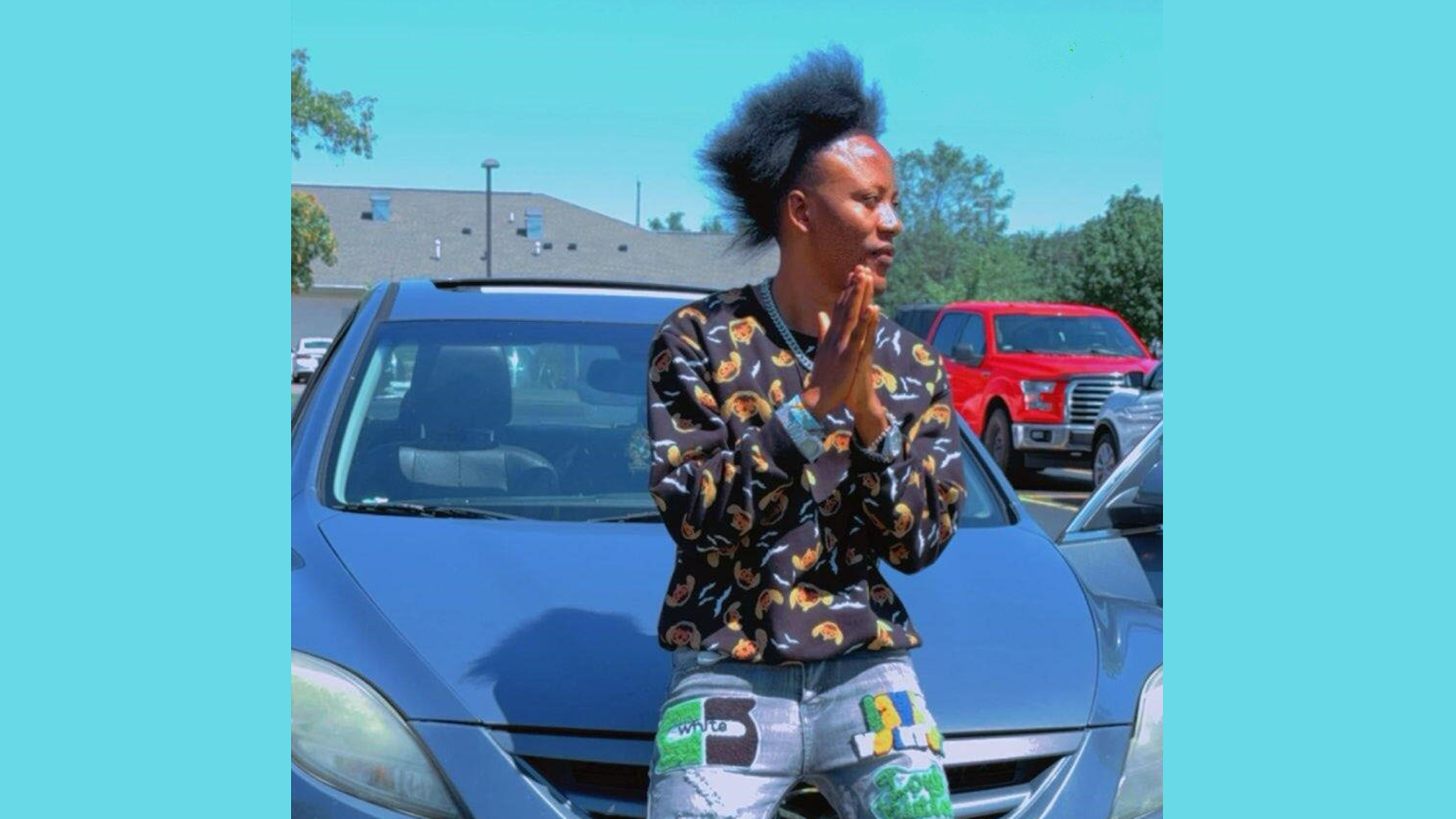 Bahati stands in front of his new car.